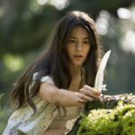 Kya (Daisy Edgar-Jones) finds a feather in Columbia Pictures' WHERE THE CRAWDADS SING.