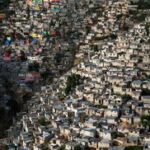 Jalousie, bidonville bordant la ville de Pétionville, banlieue de Port-aux-Prince, Haïti (18° 30’ 41.57’’ N – 72° 17’ 38.80’’ O). © HUMAN The Movie
Une partie du quartier de Jalousie a été repeinte de couleurs vives en 2012. Mais les maisons restent, pour la plupart, dépourvues d’eau et d’électricité. Après le séisme de 2010, 1,3 million de personnes se sont retrouvées sans abri. Beaucoup d’entre elles ont été relogées dans des camps, mais la reconstruction tarde. À l’échelle de la planète, les bidonvilles hébergent plus de 826 millions de personnes ; ils accueillent environ 27 millions de personnes supplémentaires chaque année.